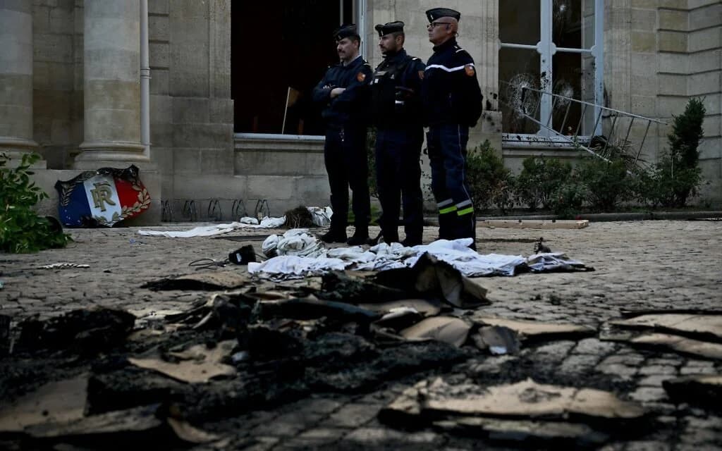 French gendarmes stand among rubble and damage at a state residence in Bordeaux